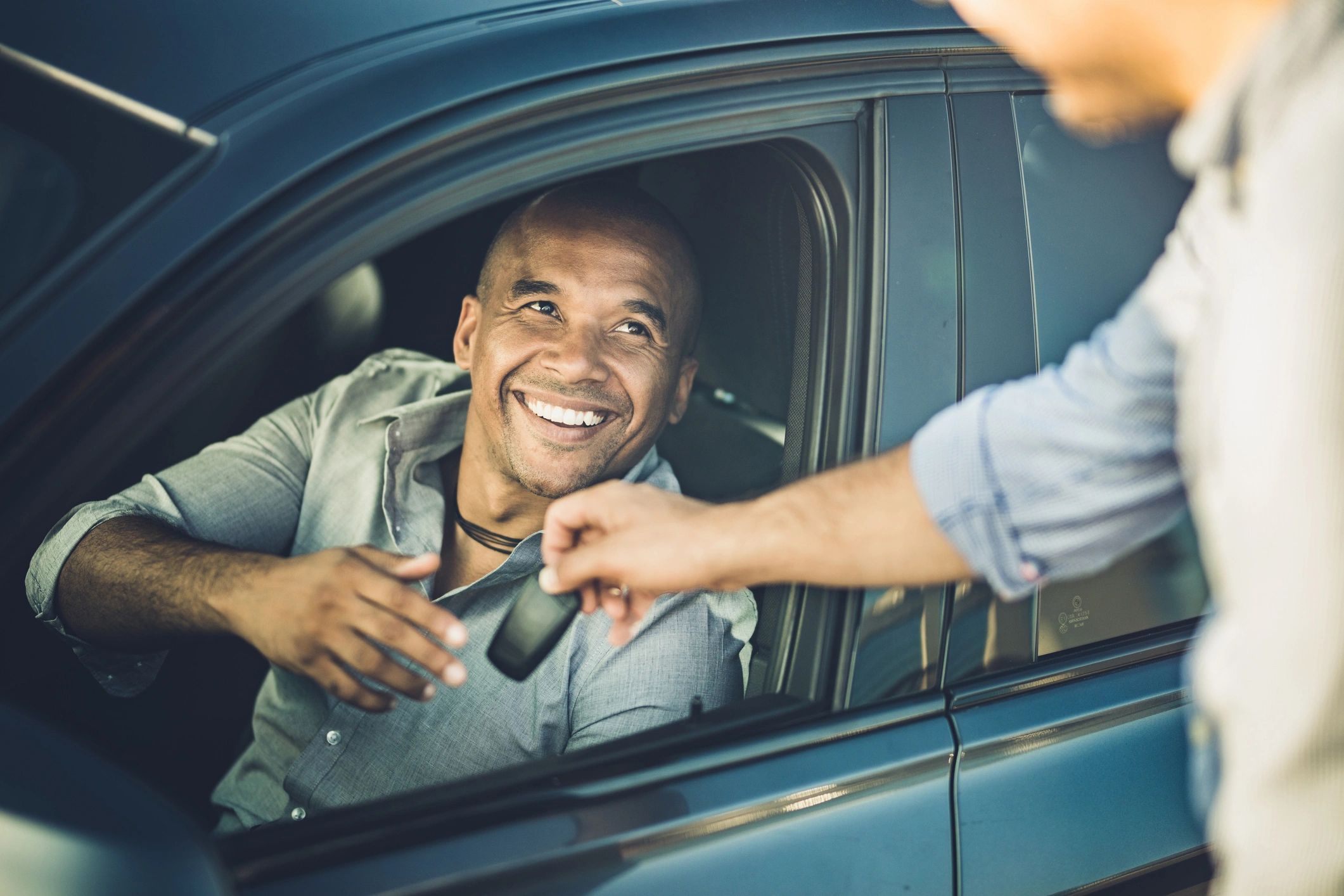 Customer receiving car keys from a salesperson