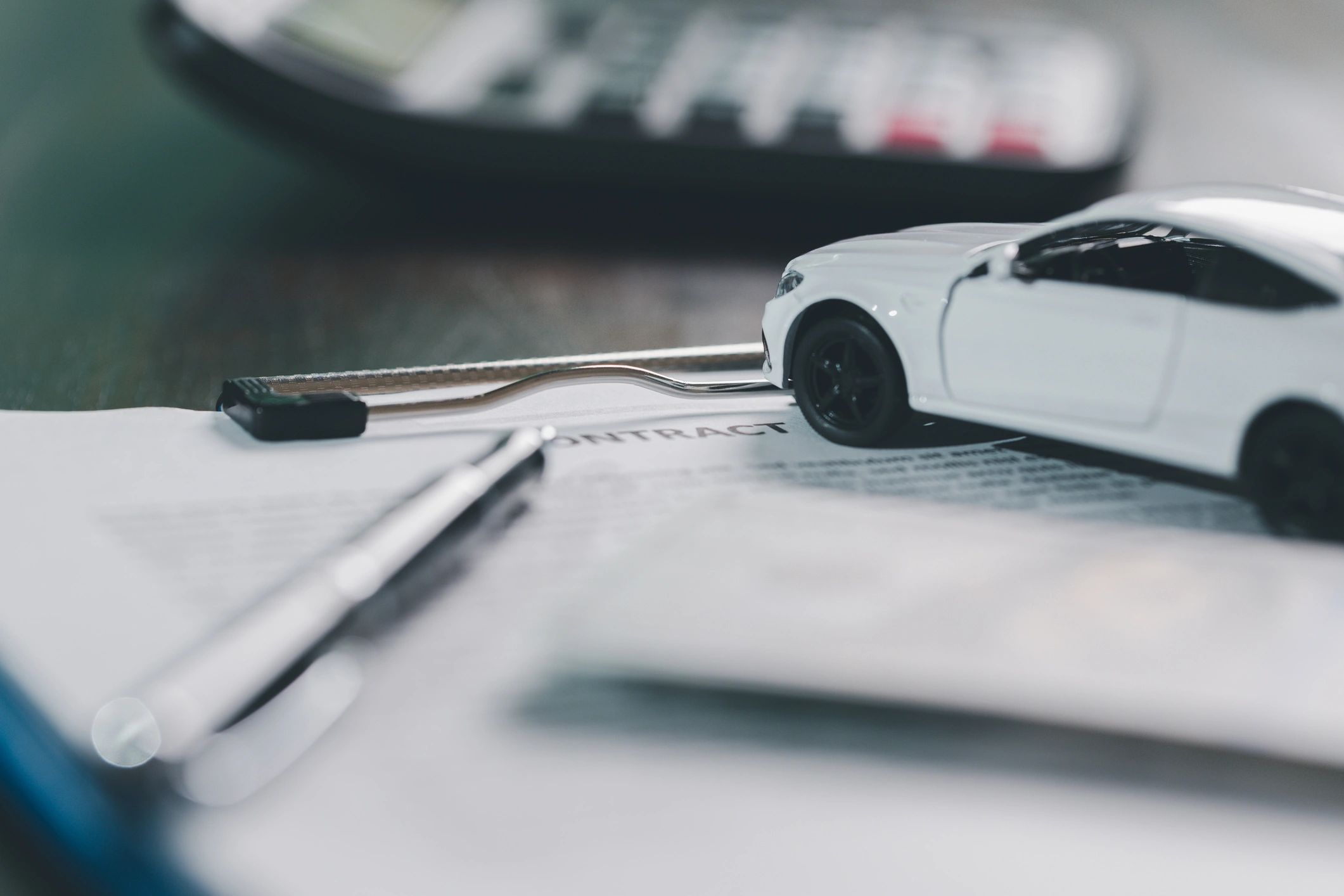 Car key being handed over above finance paperwork